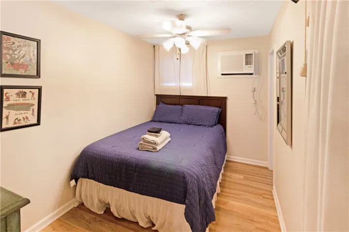 Comfortable bedroom with wood floors and a ceiling fan.