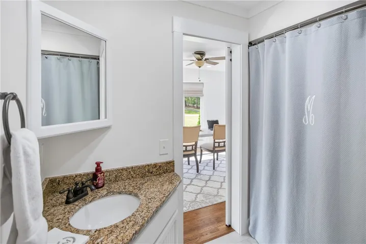 Granite counters and modern fixtures enhance this well-appointed bathroom space.