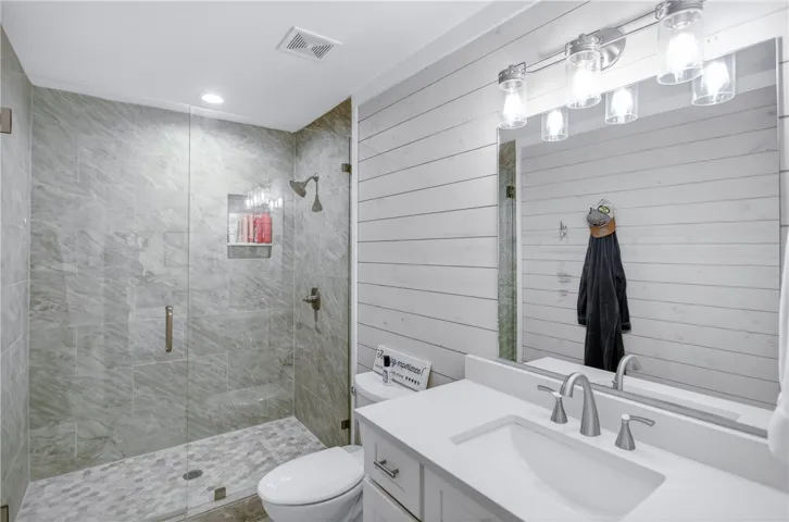 A sleek, contemporary bathroom features a spacious glass-enclosed shower and modern vanity.