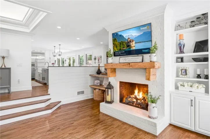 A striking brick fireplace with a rustic wood mantel creates a cozy focal point.