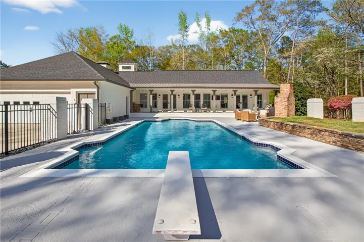 A private, in-ground pool with a diving board creates a serene backyard oasis.
