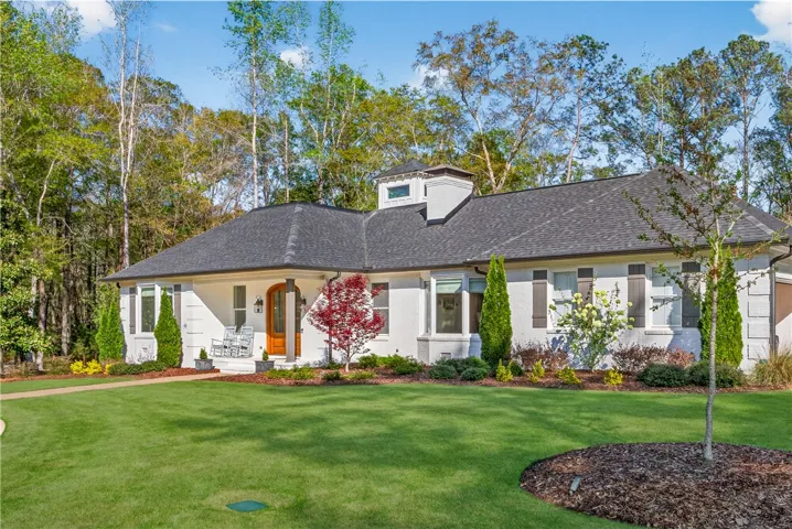 A well-maintained lawn and verdant landscaping introduce this appealing single-story residence.