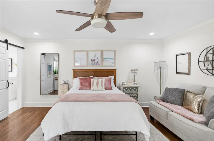 Hardwood floors and a ceiling fan create a serene and inviting atmosphere in this bedroom retreat.