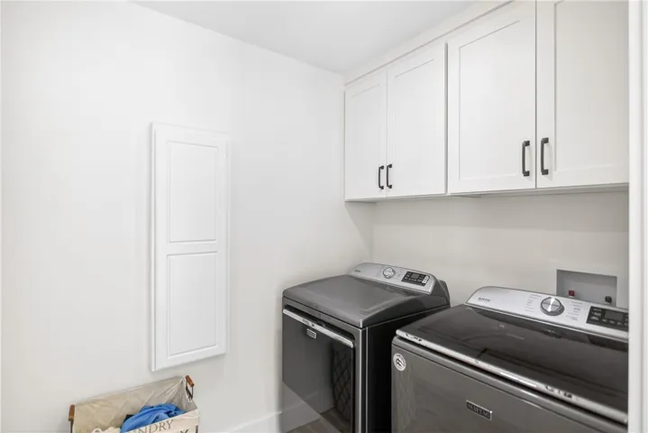 Ample storage space and a dedicated area for laundry appliances define this well-appointed utility room.