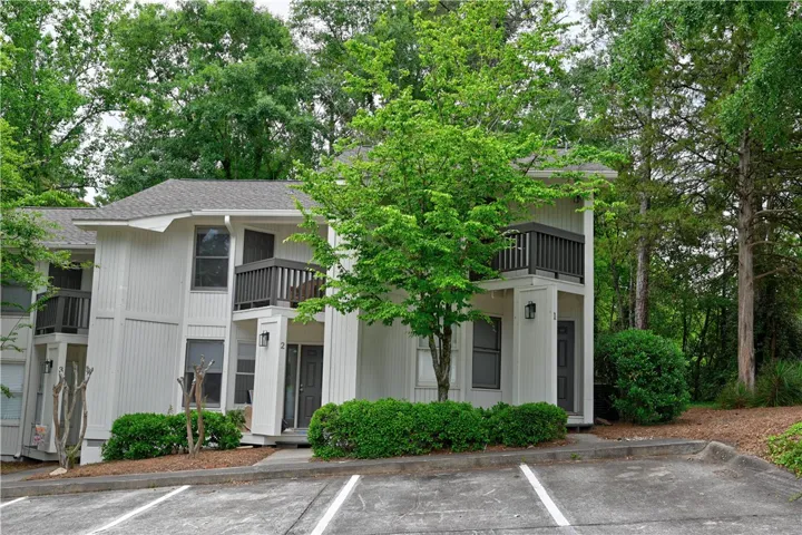 Charming townhome with private balconies offers serene living amidst lush natural surroundings.