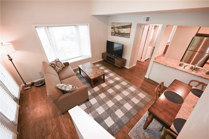 Step inside this inviting open-concept living space, featuring rich hardwood floors and a bright bay window.