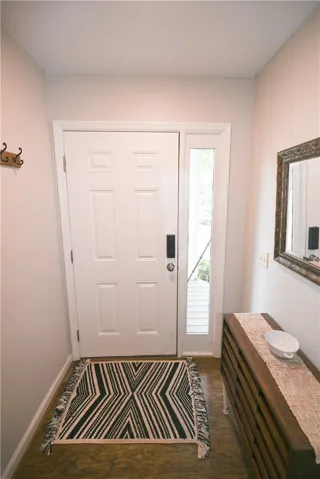 A welcoming entry features durable laminate flooring and a well-lit sidelight.