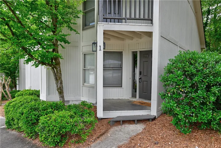 A welcoming entry featuring a covered porch, leading into a thoughtfully designed residence.