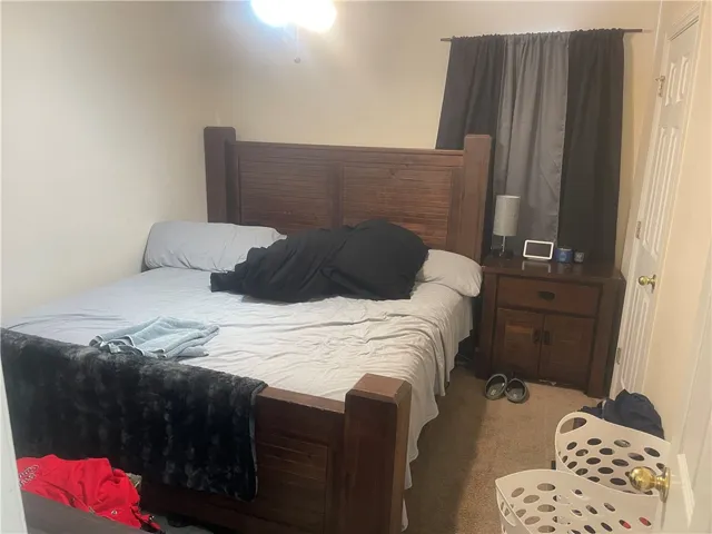 A comfortable retreat features plush carpeting and convenient bedside access to a door.