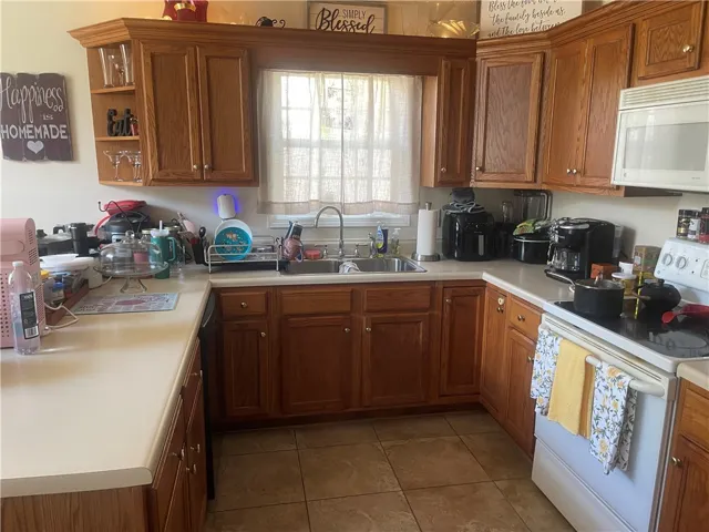 A warm and inviting kitchen featuring honey-toned wood cabinetry and essential culinary appliances.