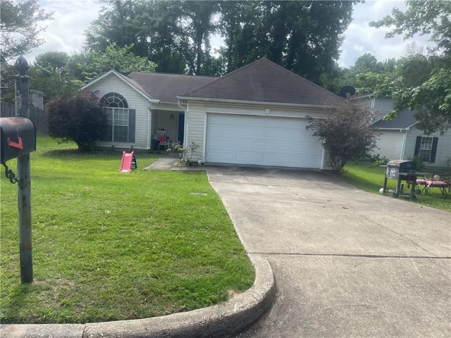 A well-maintained lawn welcomes visitors to this charming single-story residence with an attached garage.