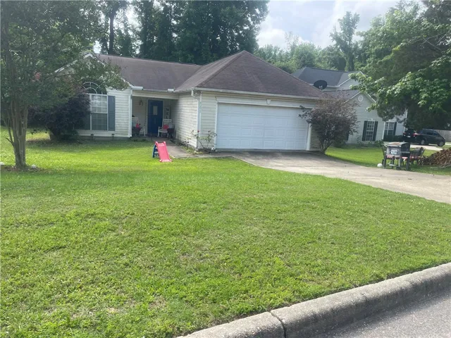 A welcoming residence features a pristine front lawn, attached garage, and charming curb appeal.