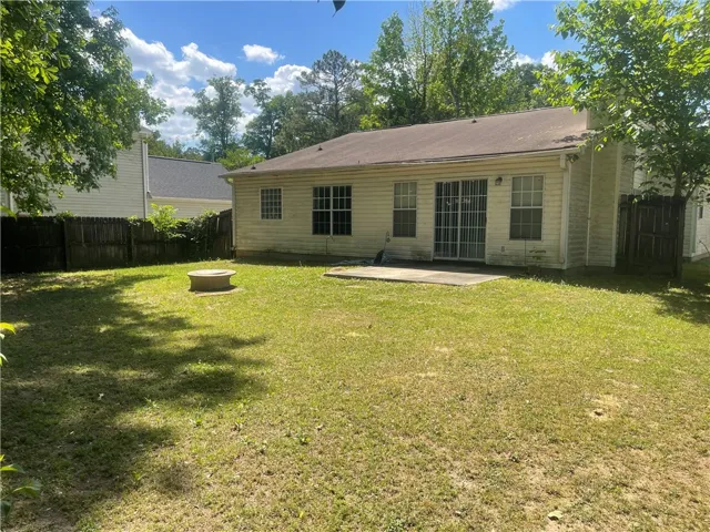 A private backyard oasis awaits, featuring a patio area and fenced perimeter for relaxed outdoor living.
