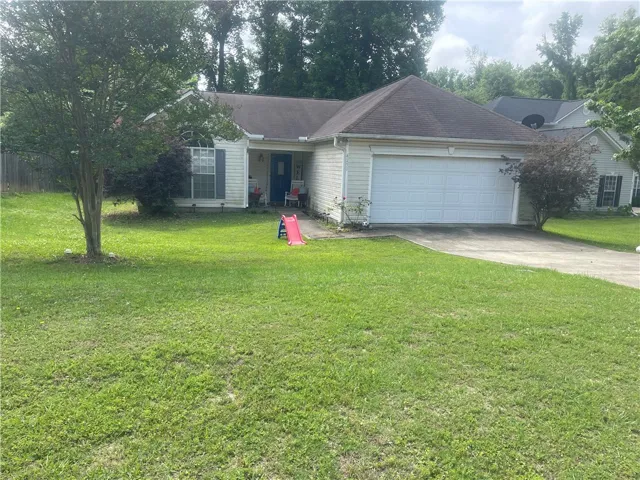 A well-maintained lawn welcomes you to this inviting residence, featuring a functional attached garage.