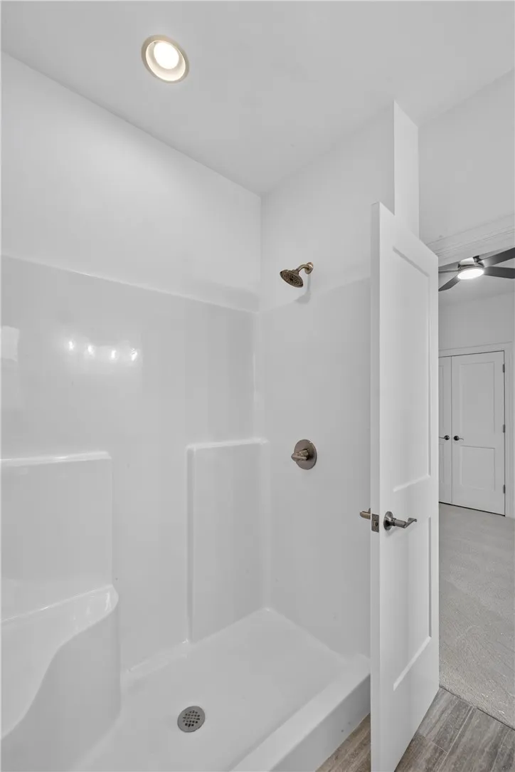 A well-lit, compact shower stall provides efficient bathing.