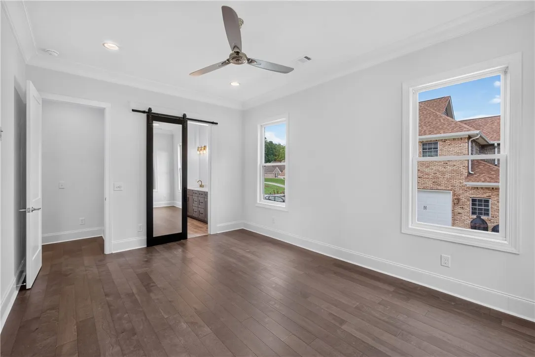 Rich hardwood floors complement high ceilings in this naturally illuminated room.