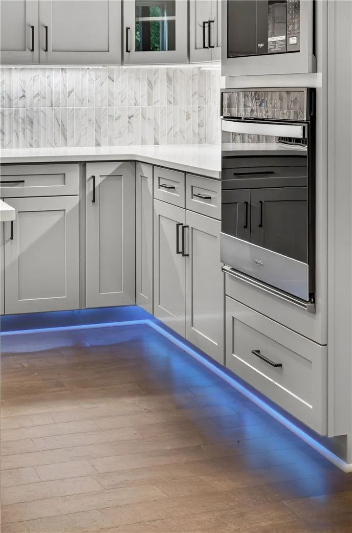A contemporary kitchen showcasing built-in appliances and under-cabinet lighting.