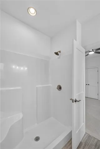 A well-lit, compact shower stall provides efficient bathing.