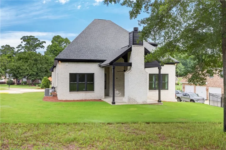 A striking modern facade with contrasting dark accents and a well-kept lawn, offering inviting curb appeal.