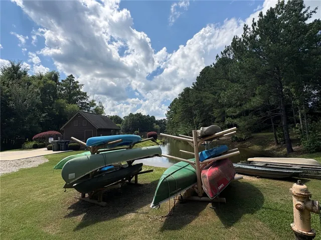 A tranquil lakeside scene with a charming boathouse and available canoes.