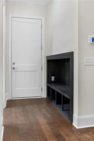 Rich hardwood floors welcome you to a practical entry space with integrated storage.