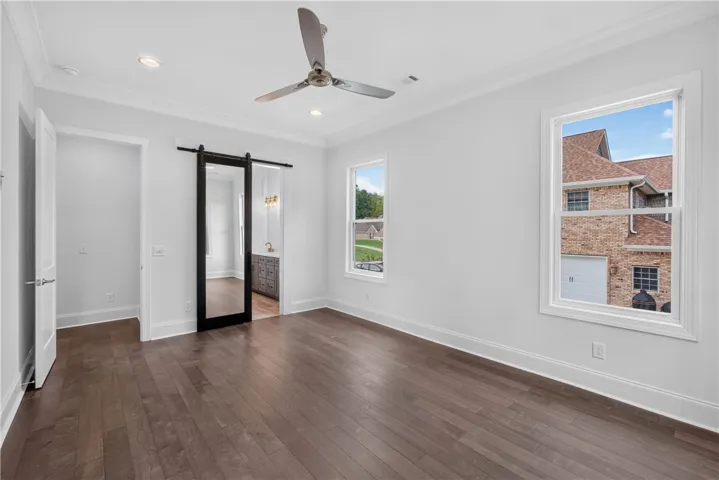 Rich hardwood floors complement high ceilings in this naturally illuminated room.