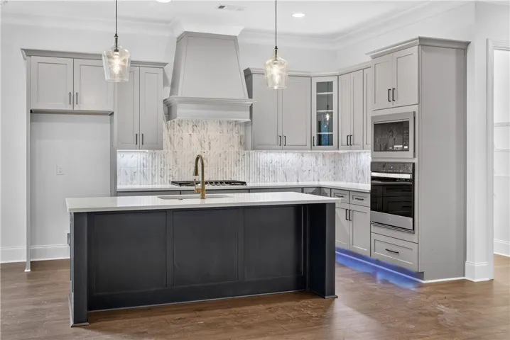 Culinary delights await in this modern kitchen, featuring sleek cabinetry and a sophisticated island with illuminated accents.