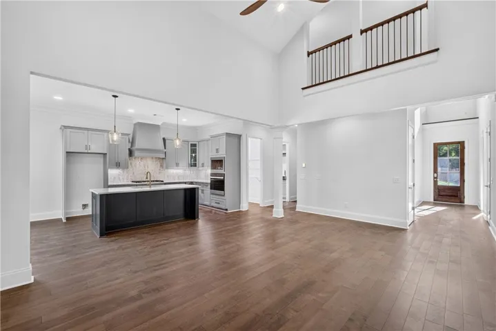 A spacious, open-concept living area with soaring ceilings and a sleek, modern kitchen.