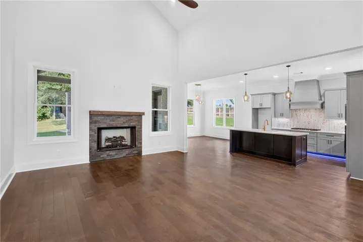 An inviting open-concept living area with a fireplace seamlessly flows into a well-appointed kitchen.
