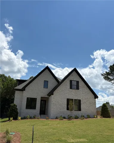 The striking modern farmhouse facade boasts black-framed windows and a well-kept lawn, offering inviting curb appeal.