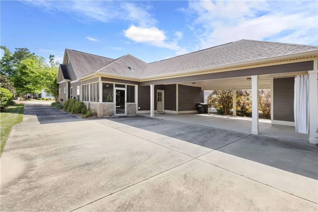 A spacious driveway and covered parking area offer convenient access to this home with a screened porch.