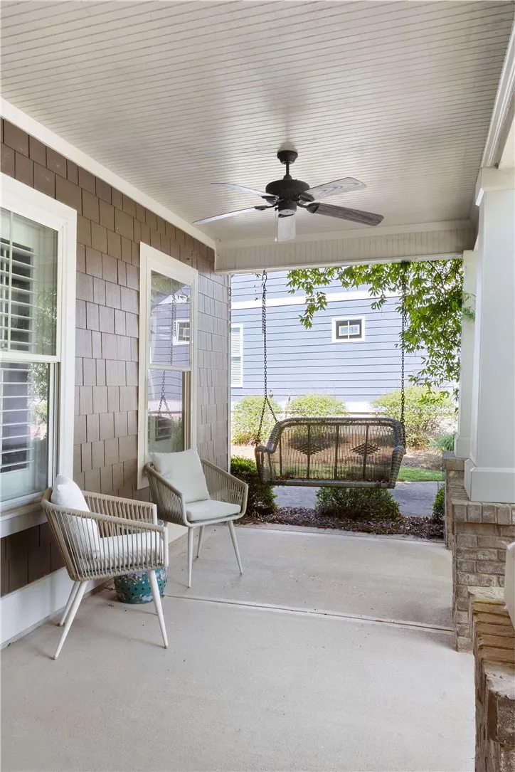 A welcoming covered porch with a ceiling fan and a charming swing offers a perfect outdoor retreat.
