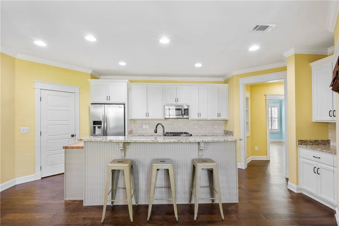 A cheerful kitchen boasts granite countertops and stainless steel appliances.