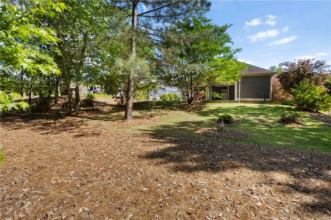 A spacious backyard with mature trees provides a peaceful, private retreat.