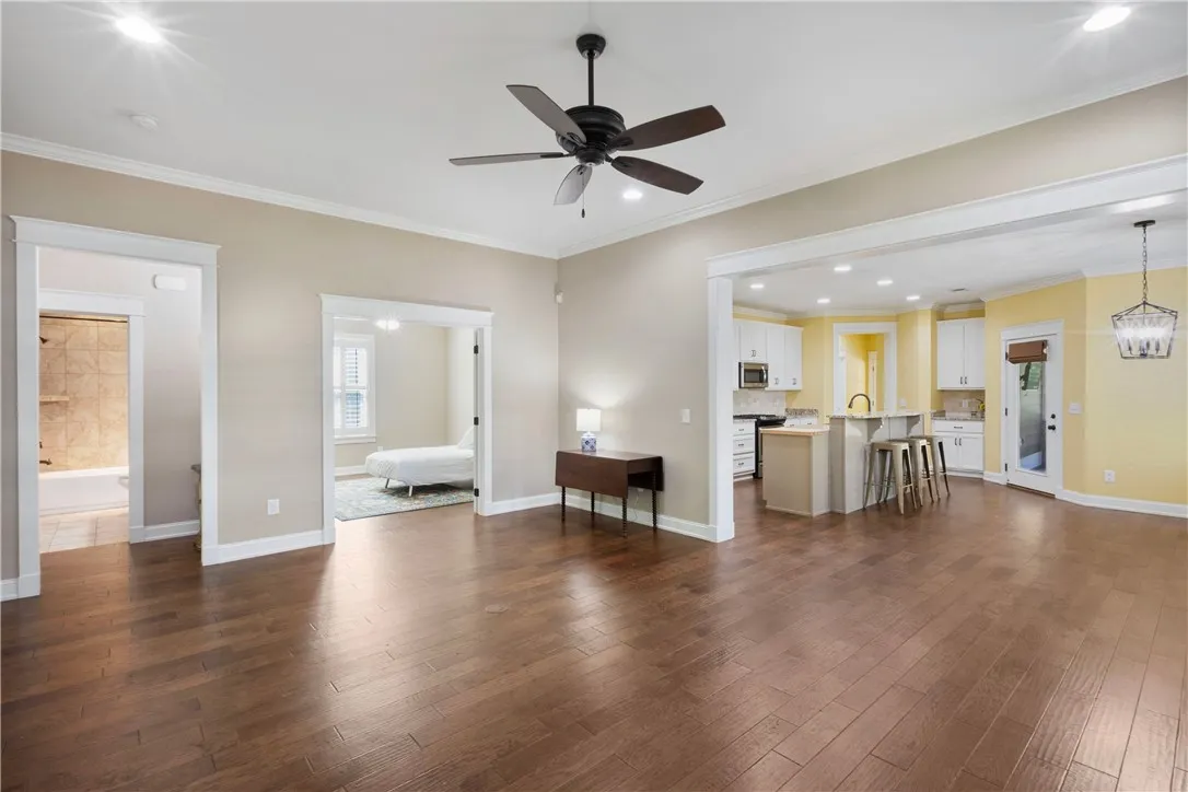 Rich wood floors flow through an open layout connecting living spaces to a sun-filled kitchen.