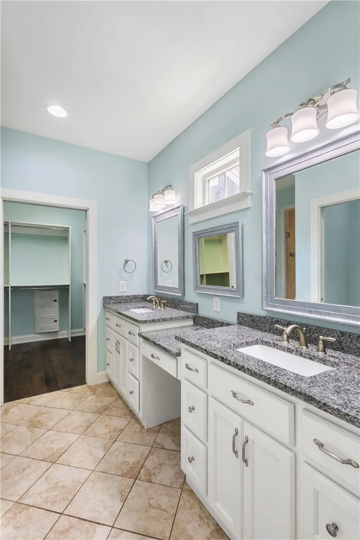Granite counters and double vanities elevate this bathroom's clean, functional design.