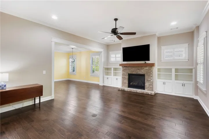 Wood floors and a brick fireplace with built-in shelving define this inviting gathering space.