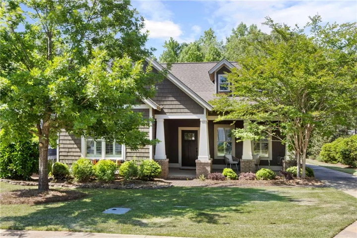 A welcoming front facade with a covered porch and neatly maintained landscaping beckons.