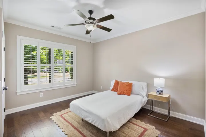 Well-lit sleeping quarters with rich wood flooring and a refreshing ceiling fan.