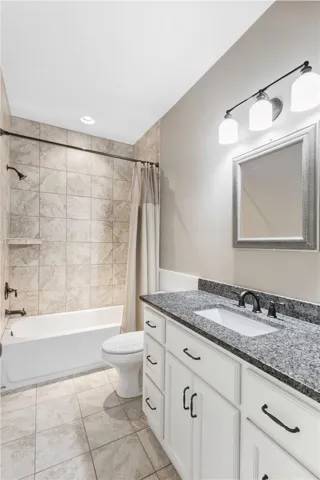 A well-appointed bathroom offers a convenient shower-over-tub combination and a single vanity with granite counters.