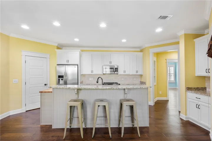 A cheerful kitchen boasts granite countertops and stainless steel appliances.