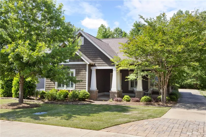 An inviting front elevation with a covered porch and verdant landscaping.