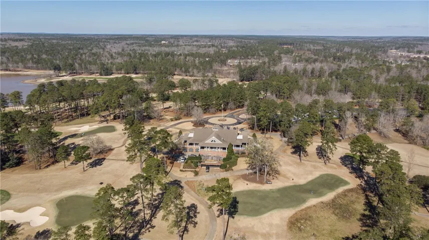 An aerial panorama showcases the sprawling golf course and elegant clubhouse by the lake's edge.