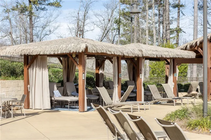 Relax in shaded cabanas by the pool, surrounded by lush green landscaping.
