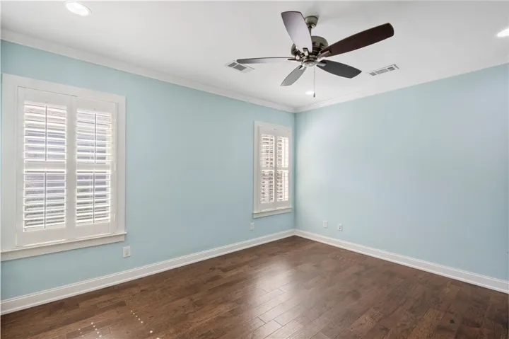 wood floors and plantation shutters adorn this charming, naturally illuminated room.