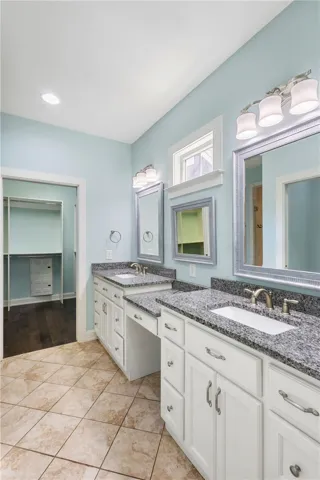 Granite counters and double vanities elevate this bathroom's clean, functional design.