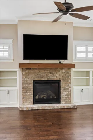 A striking brick fireplace serves as the focal point, flanked by built-in shelving.
