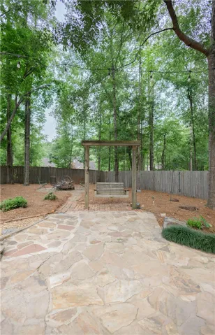 A flagstone patio leads to a serene backyard swing, perfect for quiet outdoor moments.