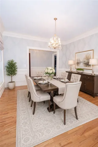 A refined dining room with lustrous hardwood floors and elegant crown molding sets a graceful tone.