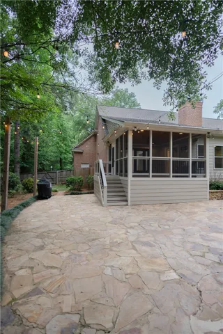 A spacious flagstone patio creates an ideal outdoor living area, complemented by a screened porch.